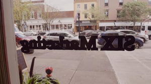the sign on six marketing's door as seen from within